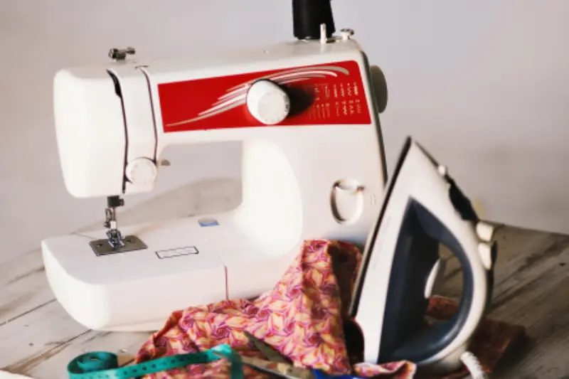Máquina de coser sobre una mesa de trabajo, vista de cerca
